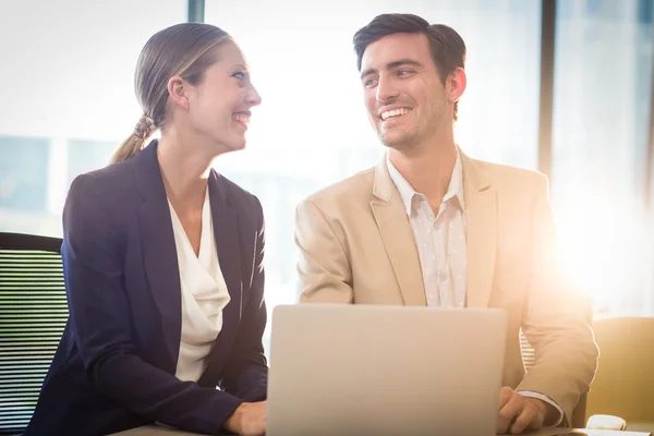 Businessman and businesswoman interacting using laptop — Stock Photo, Image