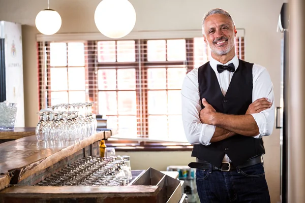 Ritratto di barista sorridente in piedi con le braccia incrociate — Foto Stock