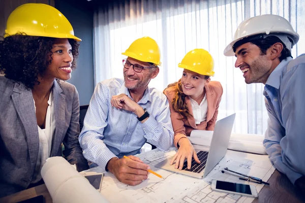 Arquitectos sonrientes interactuando entre sí — Foto de Stock