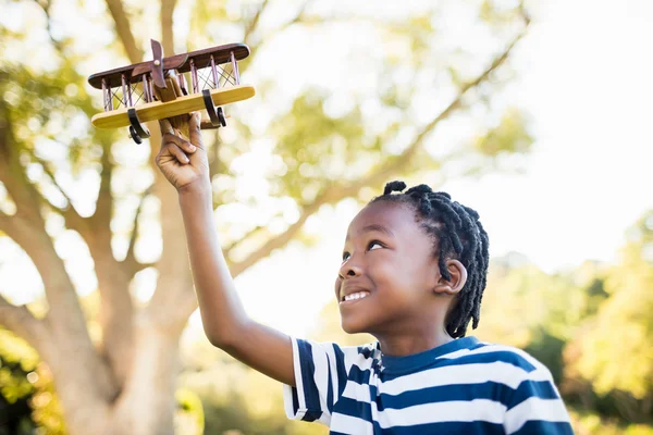 Glückliches Kind, das mit einem Flugzeug spielt — Stockfoto