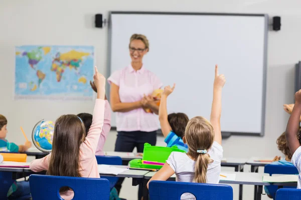 Pupils with hands up during lesson Royalty Free Stock Photos