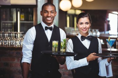 Waiter and waitress holding a serving tray  clipart