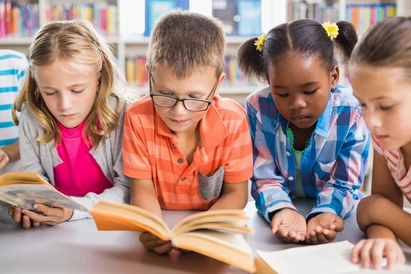 Niños leyendo un libro en la biblioteca — Foto de Stock