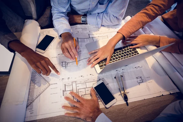 Four architects discussing blueprints in meeting — Stock Photo, Image