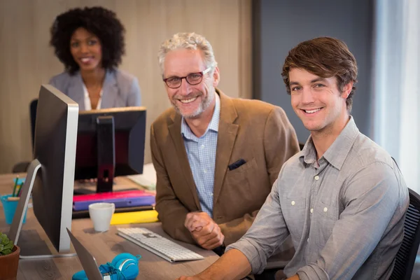 Uśmiechający się ludzie biznesu, siedząc w biurze — Zdjęcie stockowe