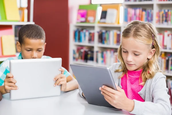 Niños usando tableta digital en la biblioteca — Foto de Stock