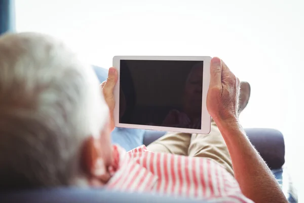 Deitado em um sofá homem sênior olhando para tablet digital — Fotografia de Stock