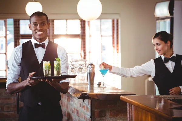 Bartender håller en serveringsbricka — Stockfoto