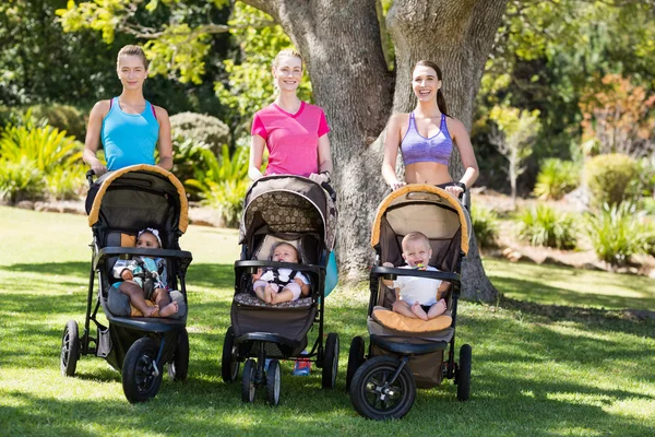 Women standing with the baby stroller — Stock Photo, Image