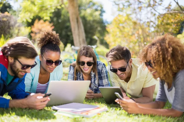 Gruppo di amici che utilizzano laptop, telefono cellulare e tablet digitale — Foto Stock