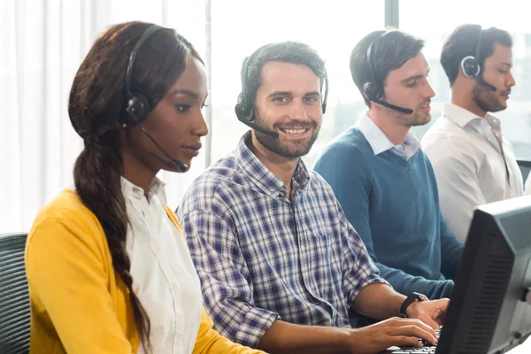 Team working on computer with headset — Stock Photo, Image