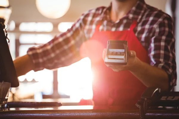 Sección media del camarero mostrando la máquina de la tarjeta de crédito — Foto de Stock