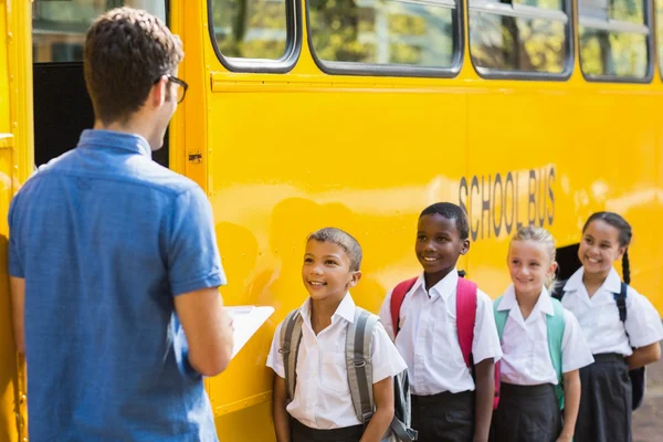 Teacher updating check list of kids — Stock Photo, Image