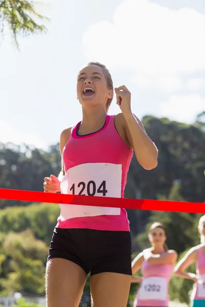 Ganador alegre atleta cruzar la línea de meta — Foto de Stock