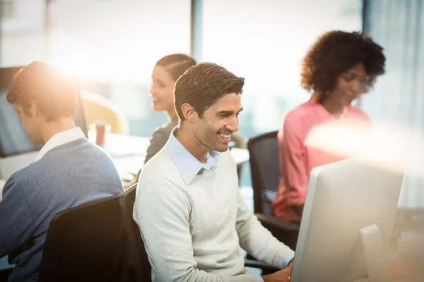 Uomo che lavora al computer con un collega — Foto Stock