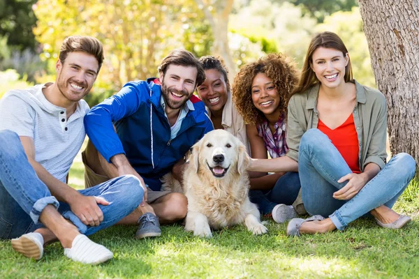 Vänner sitter tillsammans med hunden — Stockfoto