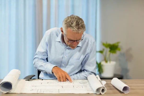 Man som arbetar på en plan vid sitt skrivbord — Stockfoto