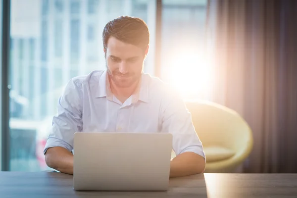 Homem usando laptop em sua mesa — Fotografia de Stock