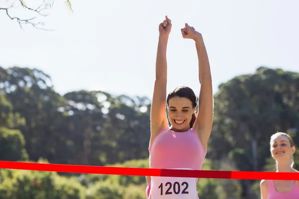 Alegre vencedor atleta cruzamento linha de chegada — Fotografia de Stock