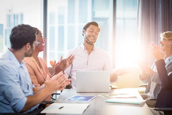 Compañeros aplaudiendo a un colega después de la presentación — Foto de Stock