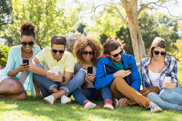 Groep vrienden met behulp van mobiele telefoon — Stockfoto