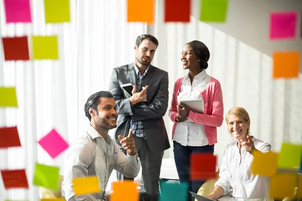 Business people discussing over adhesive notes — Stock Photo, Image