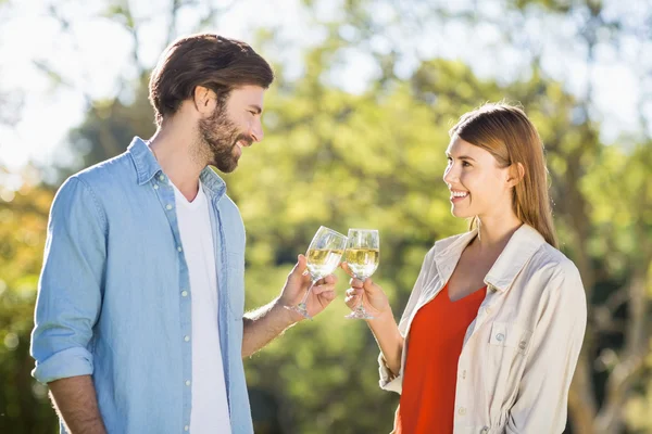 Paar stößt Weingläser an — Stockfoto