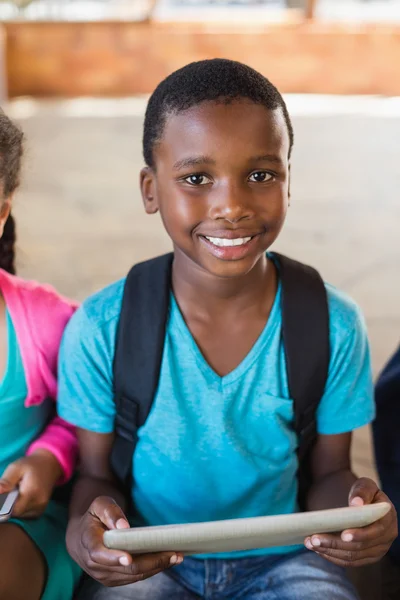 Usměvavá školák pomocí digitálních tabletu ve škole — Stock fotografie
