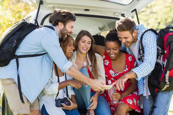 Freundeskreis schaut aufs Handy — Stockfoto