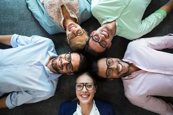 Equipo de negocios tumbado en el suelo con la cabeza junta — Foto de Stock