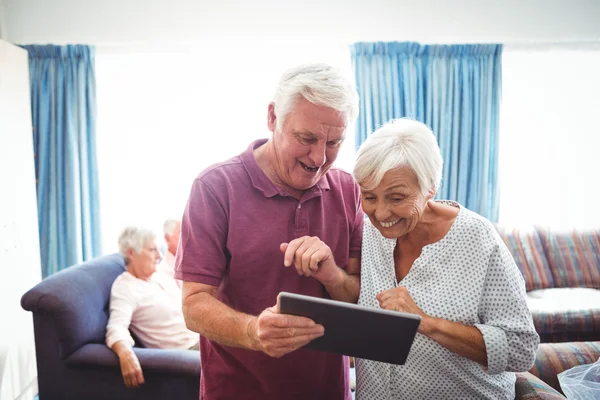 Senioren schauen auf ein digitales Tablet — Stockfoto