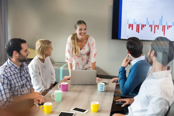 Geschäftsleute diskutieren bei einem Meeting über Grafik — Stockfoto