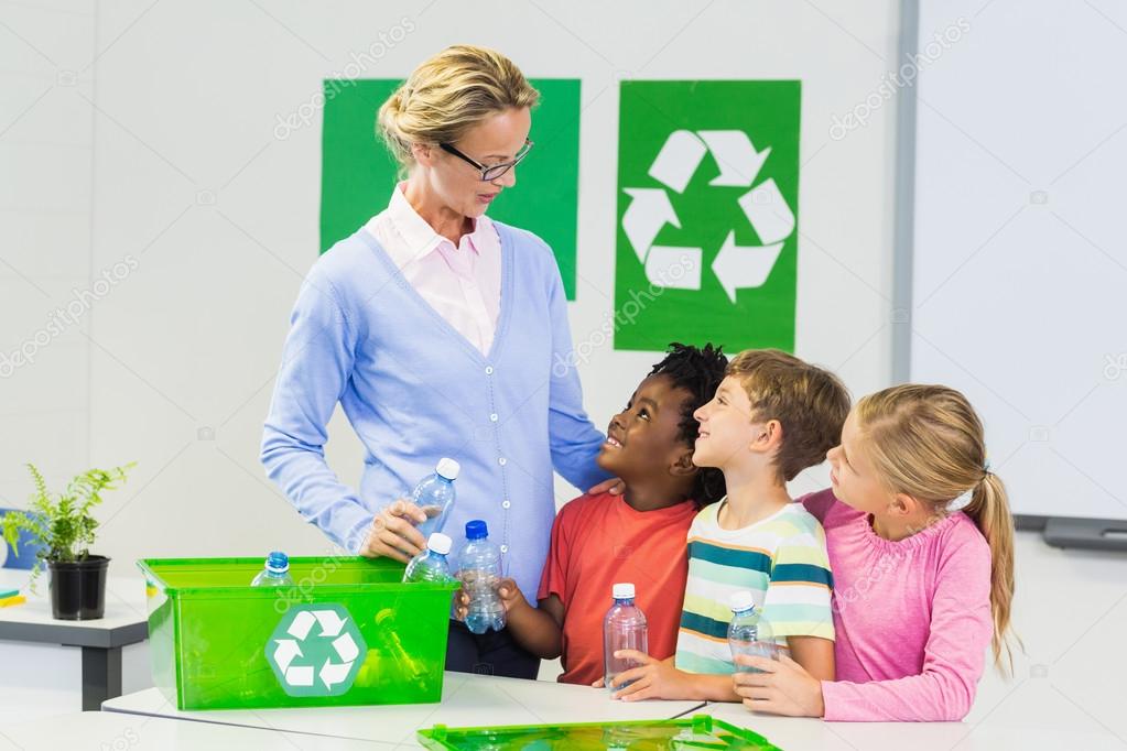 Teacher and kids interacting with each other in classroom at school