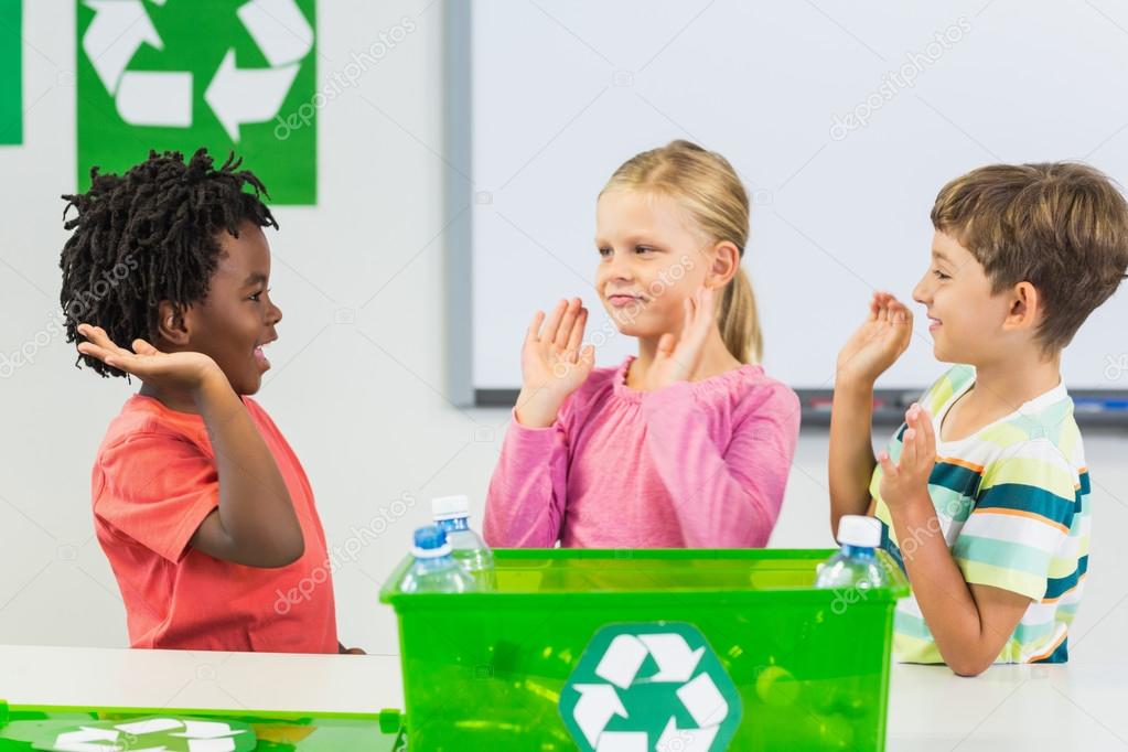 Kids giving high five to each other in classroom at school