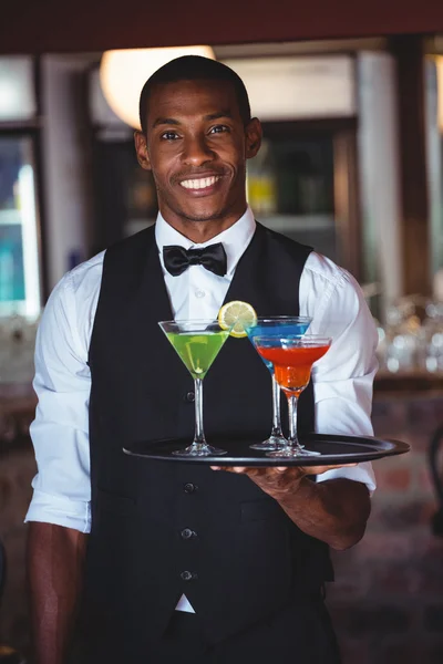 Portrait of bartender holding serving tray