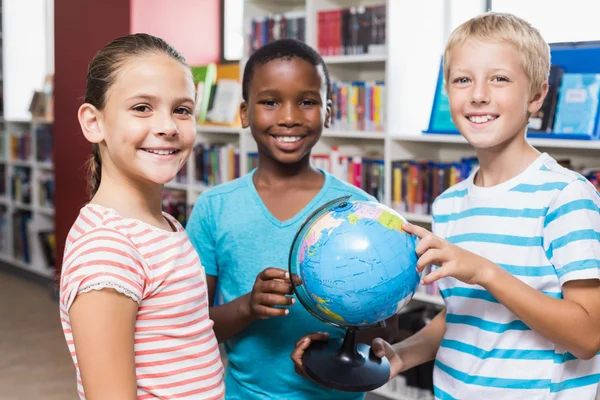 Kinderen houden van globe in bibliotheek — Stockfoto