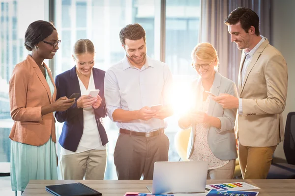 Grupp av business folk SMS på mobiltelefon — Stockfoto