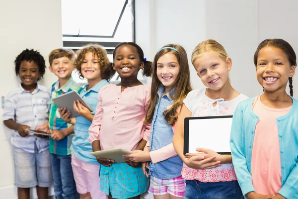 Retrato de alunos segurando tablet digital em sala de aula — Fotografia de Stock