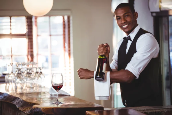 Retrato de barman segurando uma garrafa de vinho — Fotografia de Stock