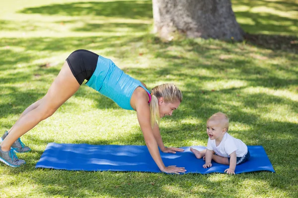 Женщина упражняется со своим ребенком — стоковое фото