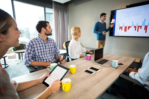 Geschäftsleute diskutieren bei einem Meeting über Grafik — Stockfoto