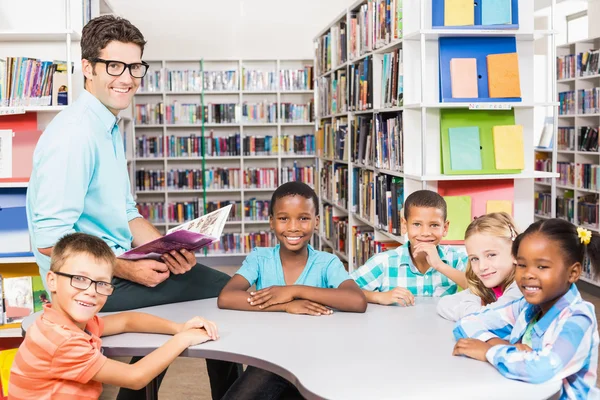 Portrait of teacher and kids in library — Stock Photo, Image