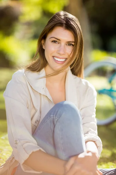 Beautiful woman sitting in park — Stock Photo, Image