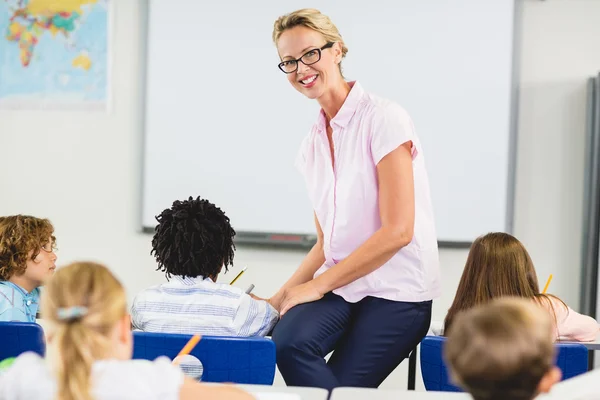 Professor ajudando crianças com seus trabalhos de casa em sala de aula — Fotografia de Stock