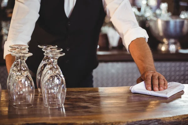 Sección media del camarero limpiando un mostrador de bar — Foto de Stock