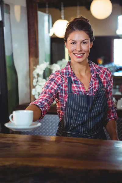 Camarera sosteniendo una taza de café — Foto de Stock