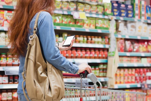 Klant in een winkel met een smartphone — Stockfoto