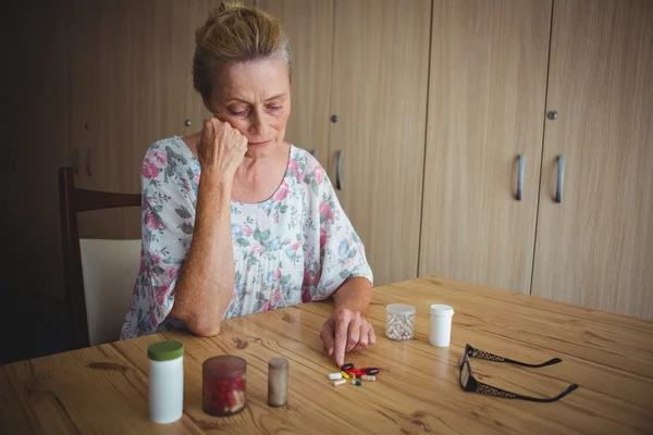 Mulher idosa com médicos na mesa — Fotografia de Stock