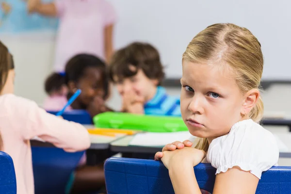 Portrait of sad schoolgirl sitting in the classroom — Stock Photo, Image