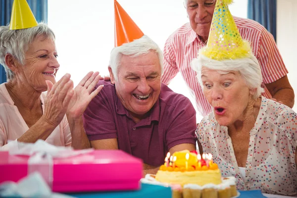 Senior woman blow on birthday cake — Stock Photo, Image